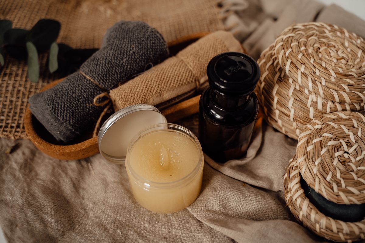 Composición de productos de cuidado corporal, toallas y velas sobre una mesa